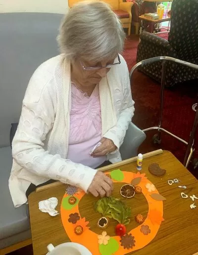 a resident creating autumn crafts